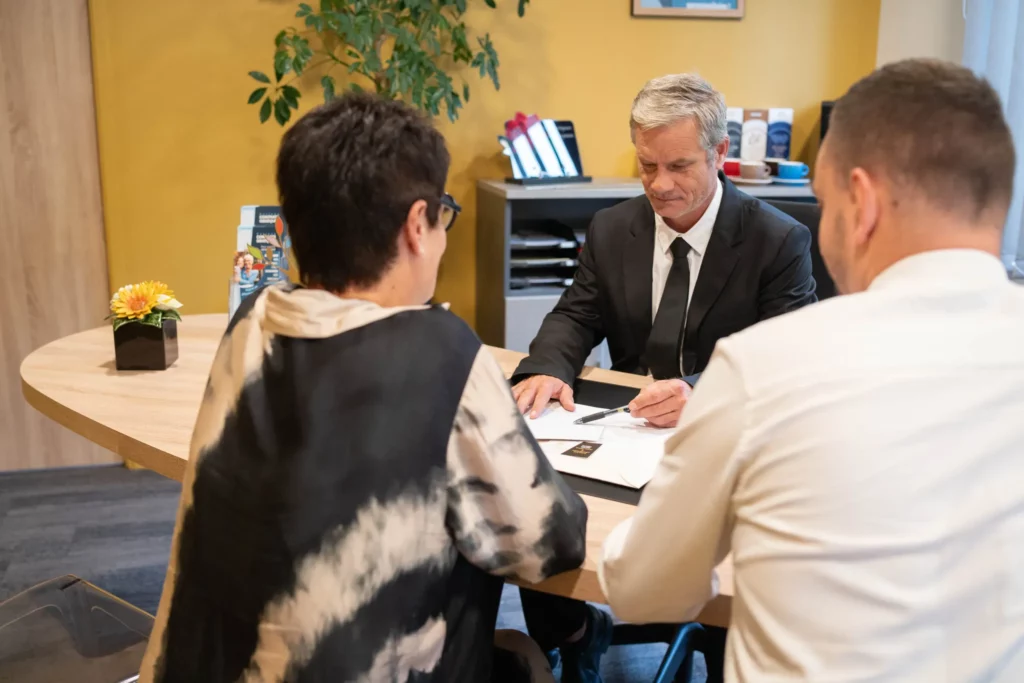 Conseiller funéraire expliquant un contrat ou devis à un couple lors d'un entretien